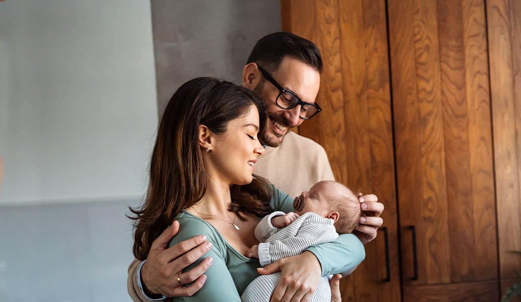 A man and woman hold their baby.