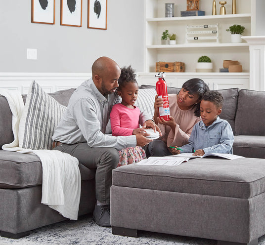 A family sits in their living room while looking at fire safety products.