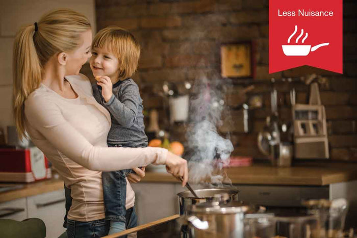 Mother holding her son while cooking a meal with an overlaid less nuisance icon